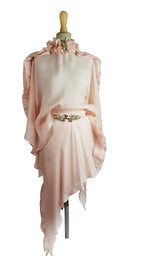 Pink dress with floral details on a mannequin against a gray background