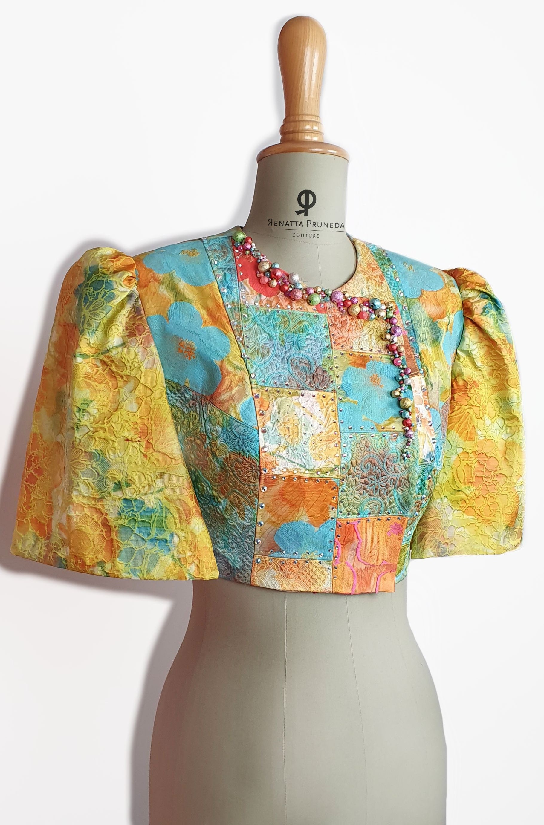 Colorful patterned top on a mannequin against a white background