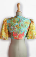 Colorful floral-patterned blouse on a mannequin against a white background