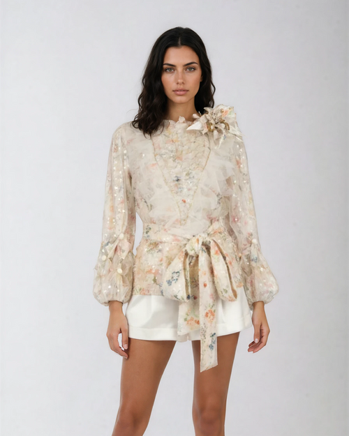 Woman wearing a floral blouse and white shorts on a white background